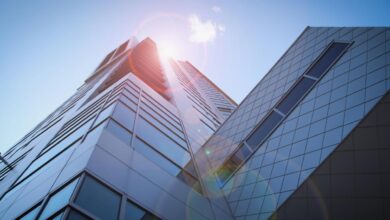low-angle photography of blue glass walled buildings under blue and white sky