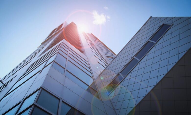 low-angle photography of blue glass walled buildings under blue and white sky