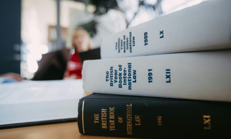 Legal books are stacked on a desk.